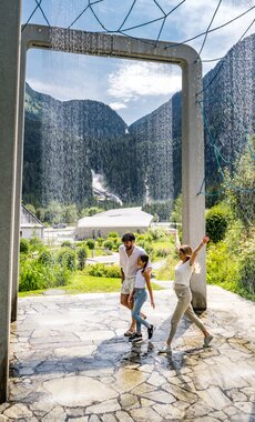 Familie geht durch den Wasservorhang im Aquapark | © krimmler-wasserwelten.at/Stabentheiner